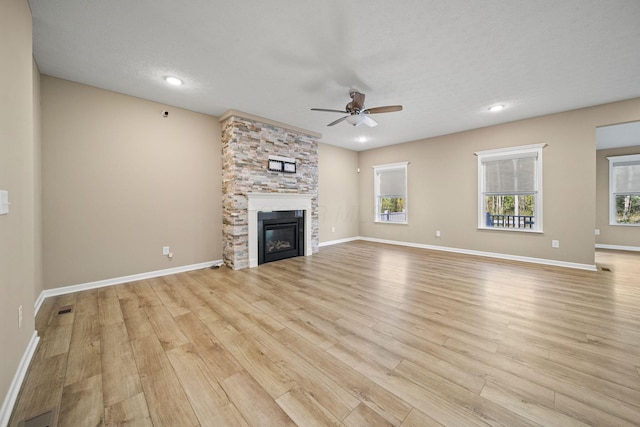 unfurnished living room featuring recessed lighting, ceiling fan, light wood finished floors, and a stone fireplace
