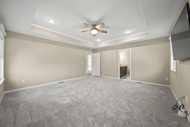 unfurnished bedroom featuring carpet floors, ornamental molding, and a raised ceiling