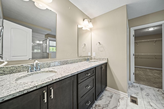 bathroom featuring a sink, baseboards, a stall shower, and marble finish floor