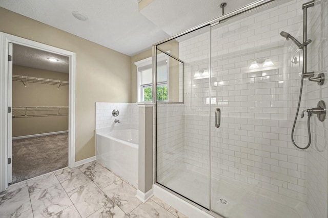 full bath featuring a bath, a shower stall, baseboards, marble finish floor, and a spacious closet
