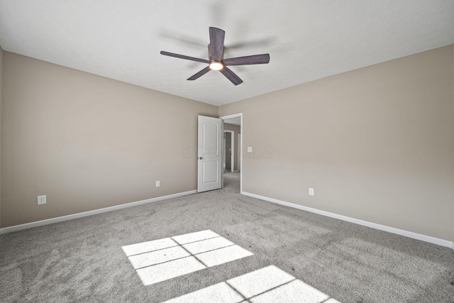 carpeted empty room with ceiling fan and baseboards