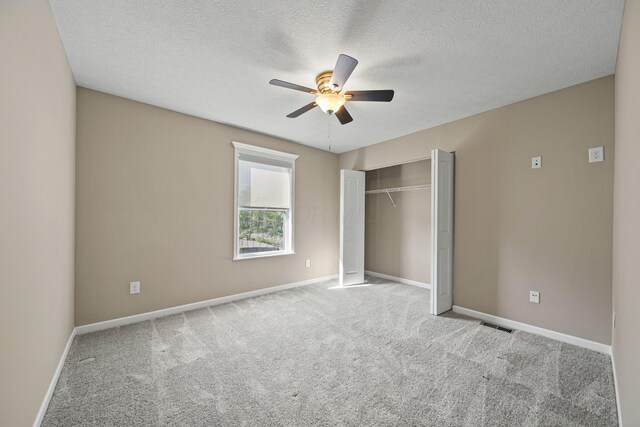unfurnished bedroom featuring ceiling fan, visible vents, carpet floors, baseboards, and a closet