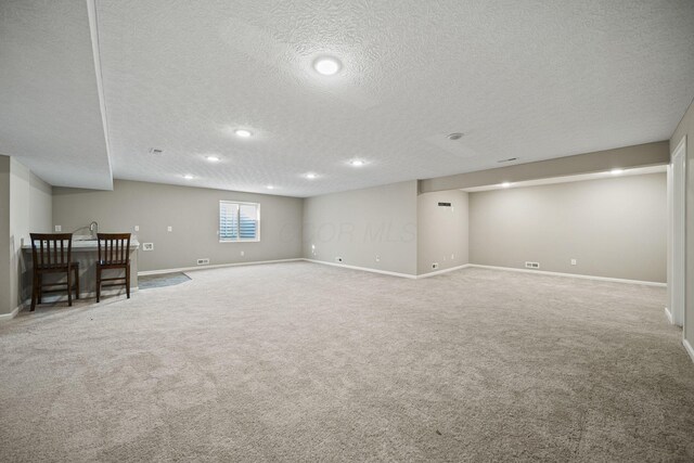 below grade area with baseboards, carpet, a textured ceiling, and recessed lighting