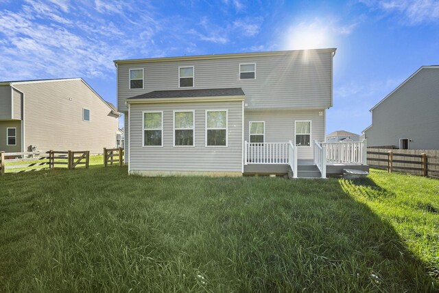 back of house with a fenced backyard, a wooden deck, and a lawn