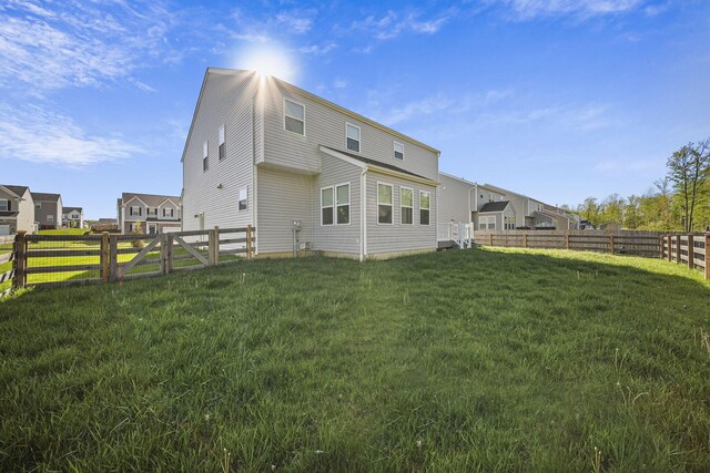 rear view of property featuring a fenced backyard and a yard