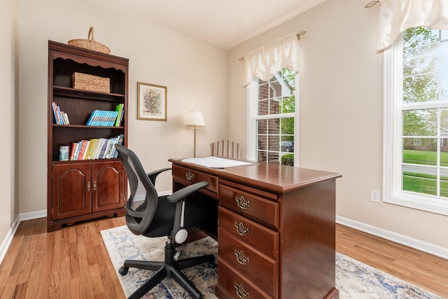 home office with baseboards and light wood-style flooring