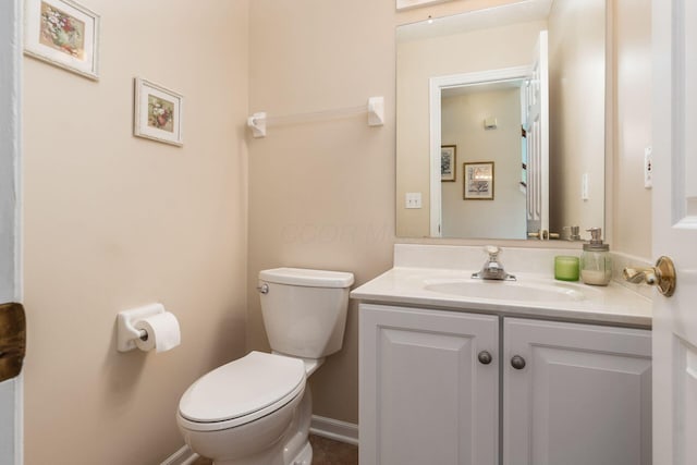 bathroom with vanity, baseboards, and toilet
