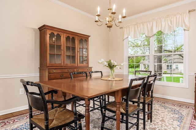 dining room with a healthy amount of sunlight, baseboards, ornamental molding, and a chandelier