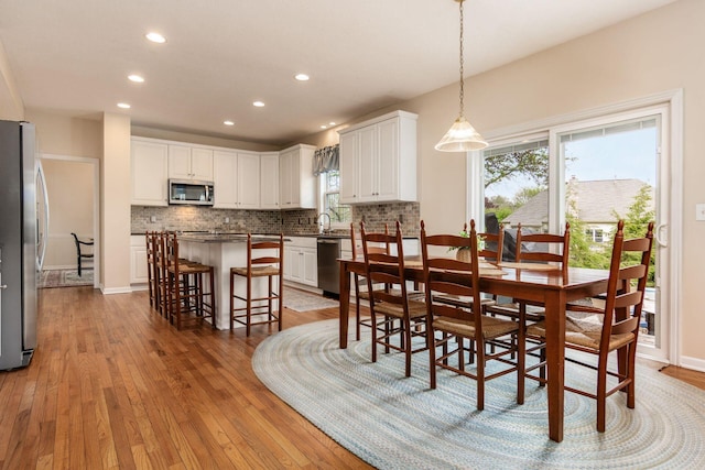 dining room with recessed lighting, baseboards, and light wood finished floors