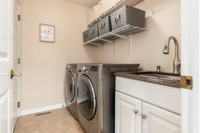 clothes washing area with cabinet space, a sink, separate washer and dryer, baseboards, and visible vents