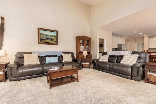 living room featuring light colored carpet, recessed lighting, and a towering ceiling