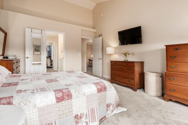 carpeted bedroom with a walk in closet, a closet, high vaulted ceiling, and visible vents
