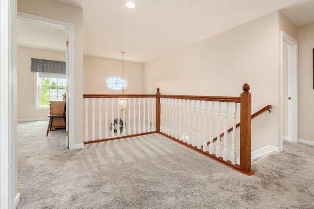 hallway featuring baseboards, carpet, recessed lighting, and an upstairs landing