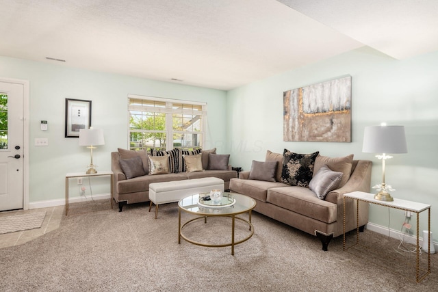 carpeted living area with baseboards and visible vents