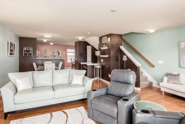 living room with baseboards, stairs, wood finished floors, and visible vents