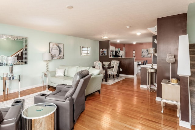 living area with baseboards and light wood-type flooring
