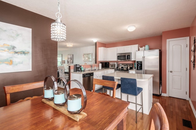 dining space featuring visible vents and wood finished floors