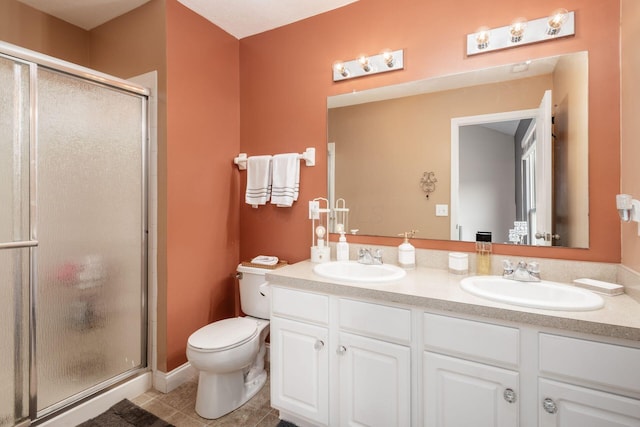 full bathroom with double vanity, a shower stall, a sink, and tile patterned flooring