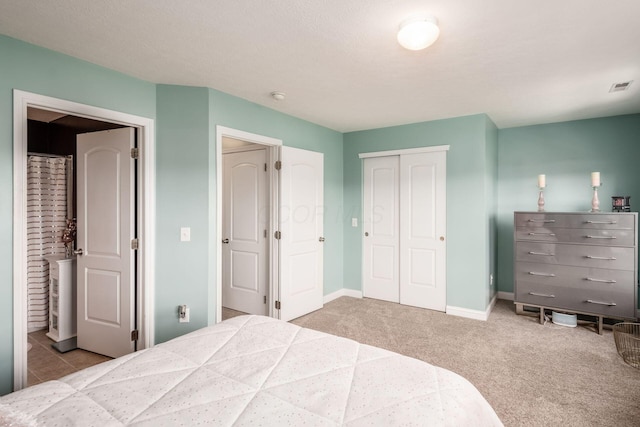 carpeted bedroom with baseboards, a closet, and visible vents