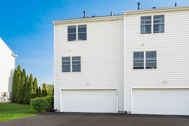 exterior space featuring an attached garage and aphalt driveway