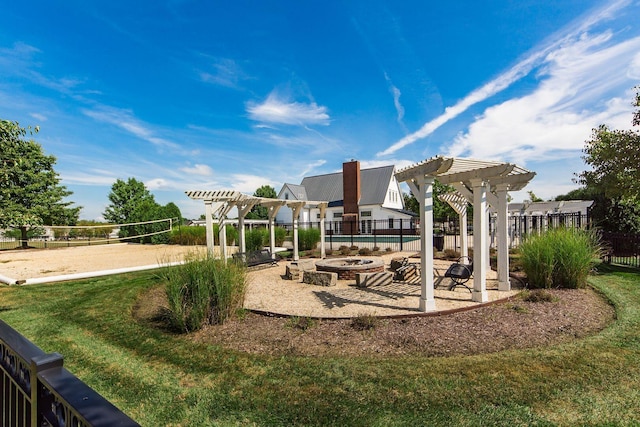 view of play area featuring volleyball court, fence, a pergola, and a lawn