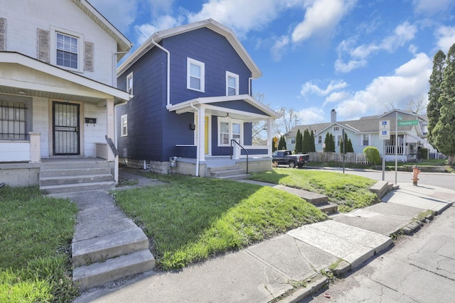 view of front of home with a front lawn, covered porch, and a residential view