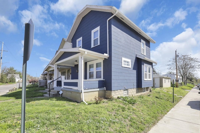 view of side of property featuring covered porch and a yard