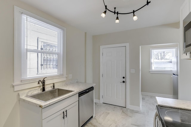 kitchen featuring stainless steel dishwasher, white cabinetry, a sink, and marble finish floor