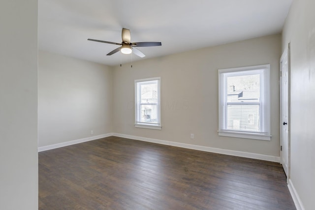 empty room featuring baseboards, a ceiling fan, and dark wood-type flooring