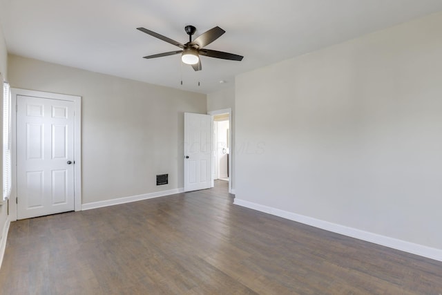 empty room featuring a ceiling fan, baseboards, and dark wood-type flooring