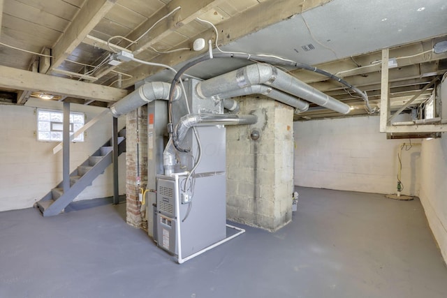 basement featuring stairway and heating unit