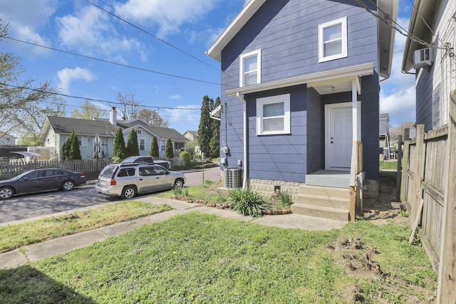 view of front of house with fence, a residential view, a front lawn, crawl space, and central air condition unit