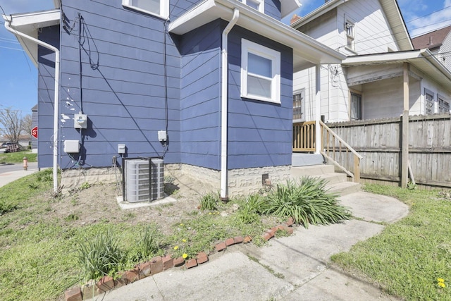 view of home's exterior with fence and central AC unit