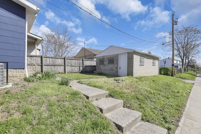 view of yard featuring central air condition unit, fence, and an outdoor structure