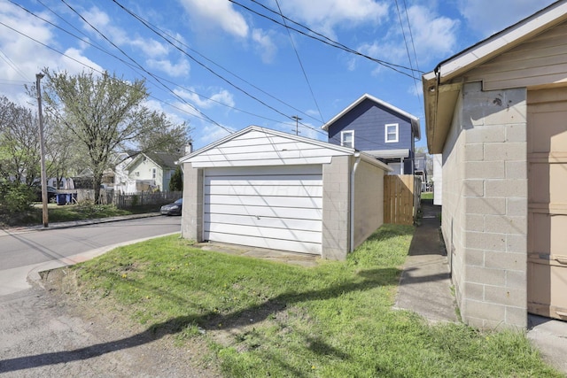 detached garage with fence and a residential view