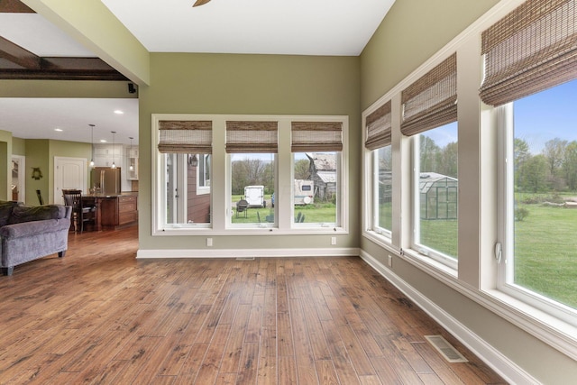unfurnished sunroom with baseboards, hardwood / wood-style floors, and visible vents