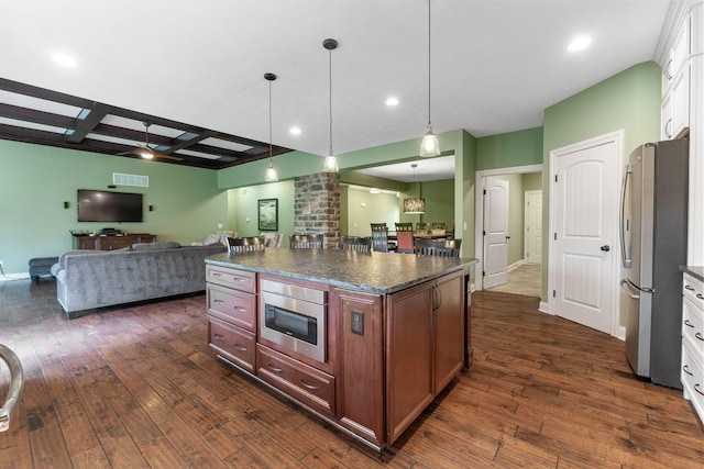 kitchen with dark countertops, freestanding refrigerator, dark wood-style flooring, and open floor plan