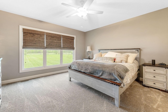 carpeted bedroom featuring baseboards, a ceiling fan, and visible vents