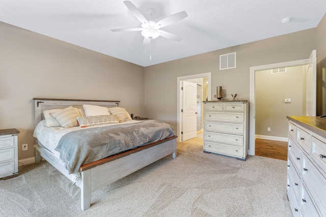 bedroom with baseboards, light colored carpet, and visible vents