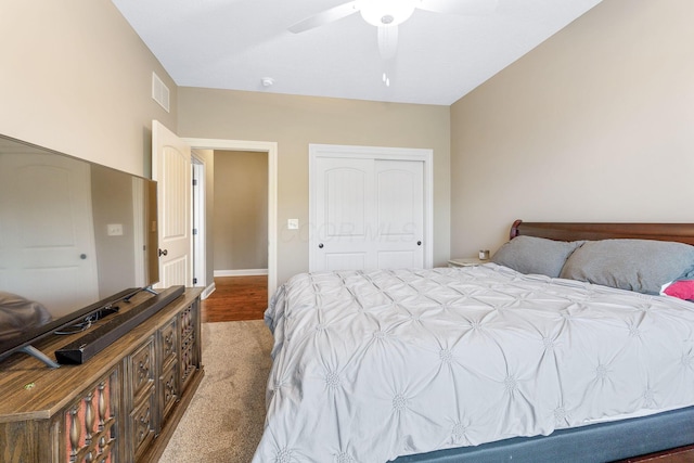 carpeted bedroom featuring ceiling fan, visible vents, and a closet