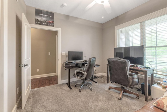 carpeted office featuring baseboards and ceiling fan