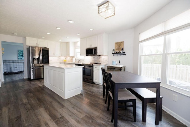 kitchen featuring light countertops, decorative backsplash, stainless steel appliances, and white cabinetry