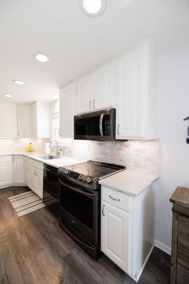 kitchen with appliances with stainless steel finishes, white cabinets, backsplash, and dark wood finished floors