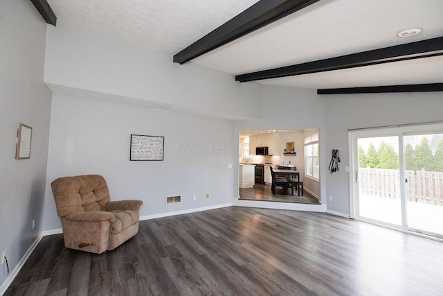 sitting room with vaulted ceiling with beams, dark wood-style flooring, baseboards, and visible vents