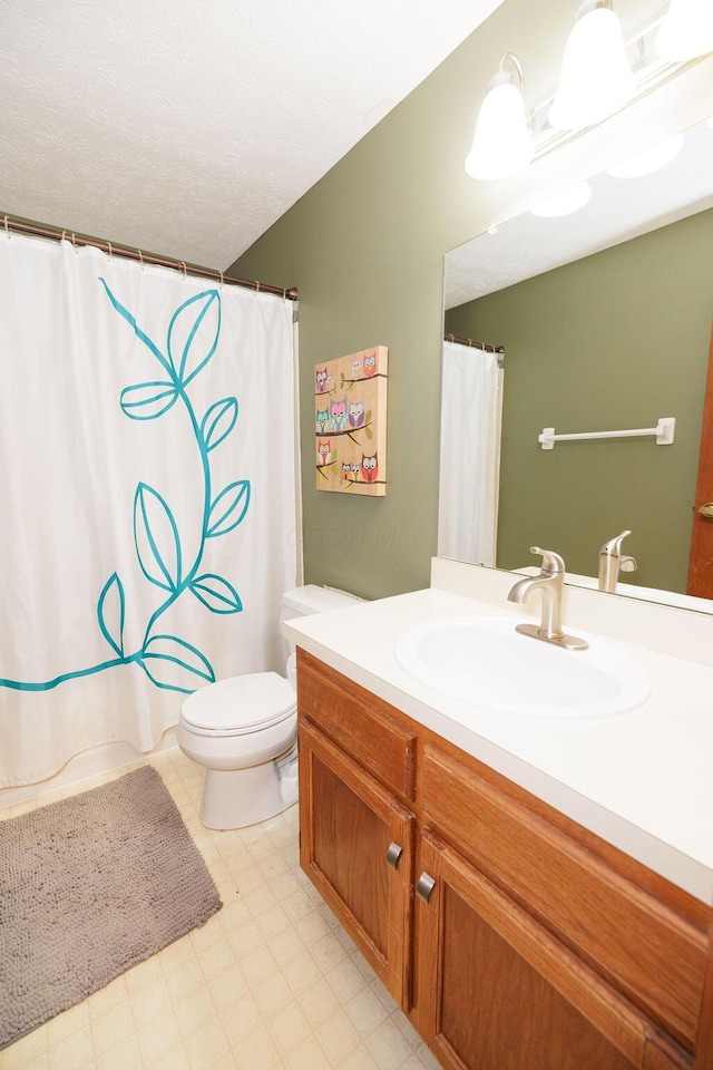 bathroom featuring vanity, curtained shower, toilet, and a textured ceiling