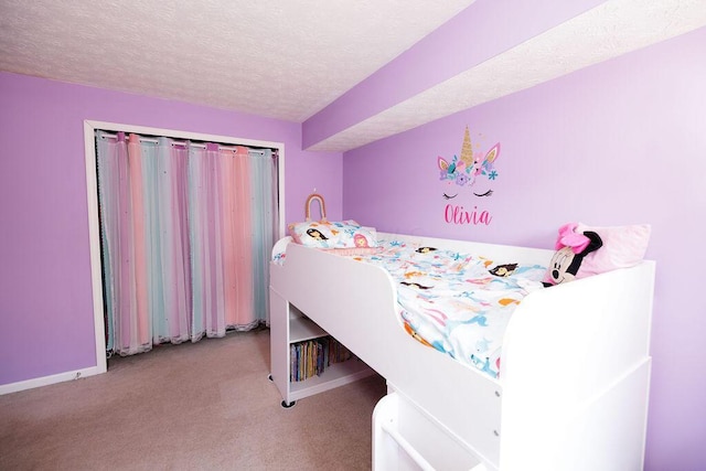 carpeted bedroom featuring baseboards and a textured ceiling