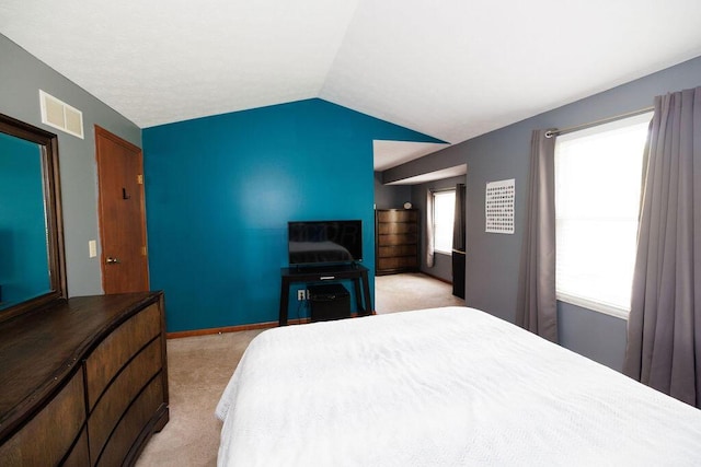 bedroom with light colored carpet, baseboards, visible vents, and lofted ceiling