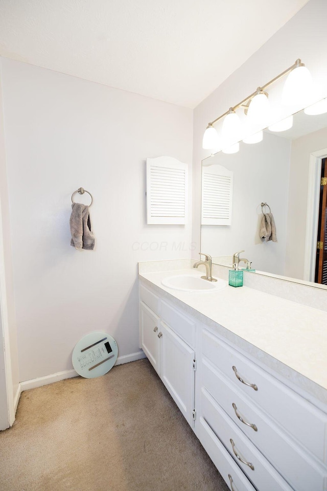 bathroom featuring vanity, carpet flooring, and baseboards
