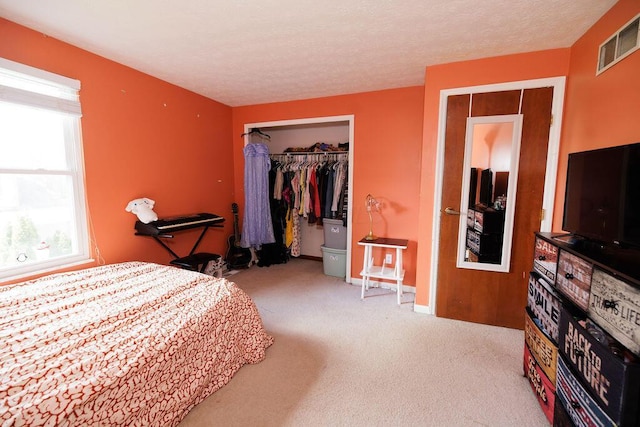 carpeted bedroom featuring baseboards, visible vents, and a closet