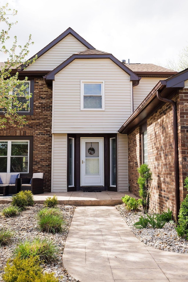 doorway to property featuring an outdoor hangout area and brick siding